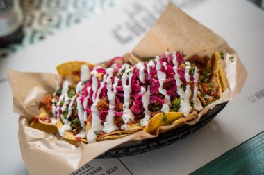 Madrid, İspanya - 20 Eylül 2019: gerçek Meksika yemeği ve içeceği. Otantik Meksika barbacoası, Carnitas ve Corona biralı tavuk tacosu..