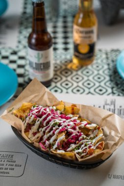 Madrid, İspanya - 20 Eylül 2019: gerçek Meksika yemeği ve içeceği. Otantik Meksika barbacoası, Carnitas ve Corona biralı tavuk tacosu..