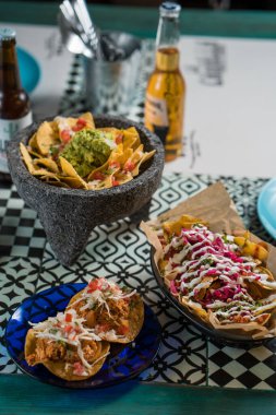 Madrid, İspanya - 20 Eylül 2019: gerçek Meksika yemeği ve içeceği. Otantik Meksika barbacoası, Carnitas ve Corona biralı tavuk tacosu..