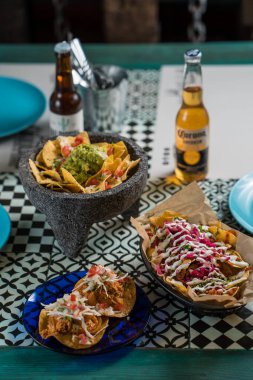 Madrid, İspanya - 20 Eylül 2019: gerçek Meksika yemeği ve içeceği. Otantik Meksika barbacoası, Carnitas ve Corona biralı tavuk tacosu..