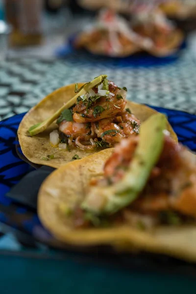 Real Mexican Tacos on a plate. Real Mexican Tacos on a plate. Shrimp tacos with homemade salsa, limes and parsley on wooden board over dark background. Top view. Mexican cuisine