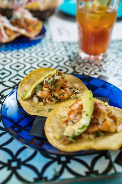 Prawdziwe meksykańskie tacos na talerzu. Prawdziwe meksykańskie tacos na talerzu. Tacos krewetki z domowej roboty salsa, limonki i pietruszki na drewnianej desce na ciemnym tle. Widok góry. Kuchnia meksykańska — Zdjęcie stockowe