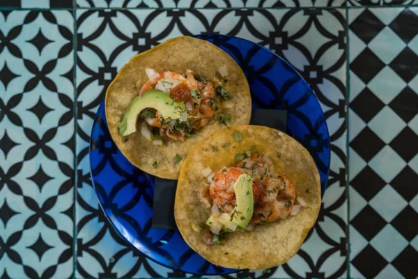 Echte Mexicaanse Taco 's op een bord. Echte Mexicaanse Taco 's op een bord. Garnalen taco 's met zelfgemaakte salsa, limoenen en peterselie op houten plank over donkere achtergrond. Bovenaanzicht. Mexicaanse keuken — Stockfoto