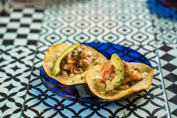 De vrais Tacos mexicains dans une assiette. Tacos aux crevettes avec salsa maison, chaux et persil sur une planche de bois sur fond sombre. Vue de dessus. Cuisine mexicaine — Photo