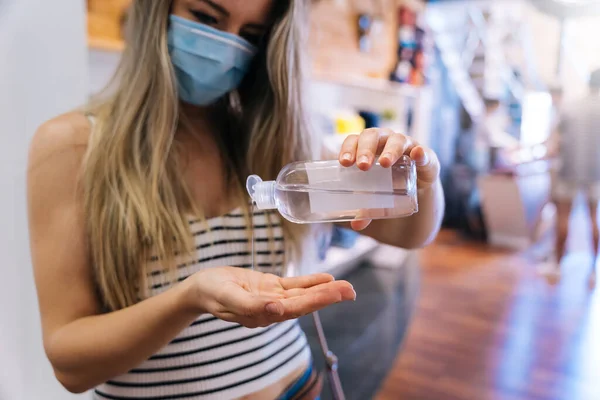 Donna che disinfetta le mani con gel idroalcolico nella pandemia coronavirica — Foto Stock