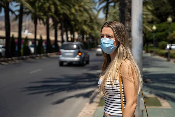 Vrouw met gezichtsmasker lopen rond de stad tijdens de coronavirus pandemie — Stockfoto