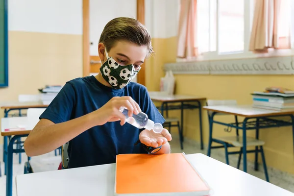 Kinderen doen ontsmettingsgel op hun handen in het klaslokaal. Koolvis. — Stockfoto