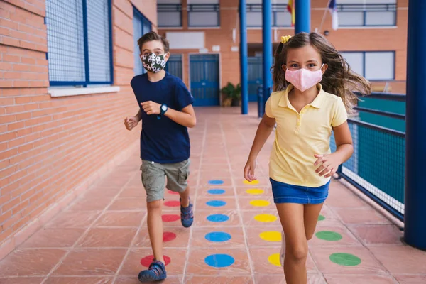 Terug naar school. Kinderen op het schoolplein met gezichtsmasker — Stockfoto