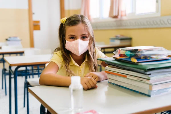 Een meisje in de klas met een masker op. tijdens een hevige pandemie — Stockfoto