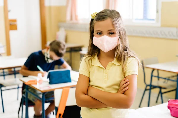 Een meisje in de klas met een masker op. tijdens een hevige pandemie — Stockfoto