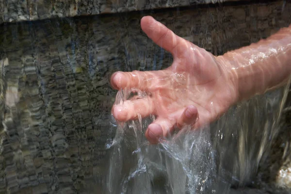 Gencin el cascade akan suyun altında. Gri doğal mermer arka plan kopya alanı ile.
