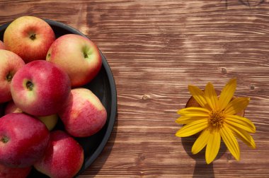 Taze hasat eski ahşap arka plan üzerinde siyah bir plaka üzerinde kırmızı elma. Ücretsiz kopya alanı ile doğa meyve kavramı üstten görünüm