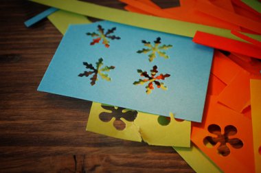 Kağıt kesiği ile bir parti ya da Noel için ev yapımı parlak renkli süslemeleri yapmak bir el sanatları kavram üzerinde kopya alanı ile rustik ahşap aşımlarını