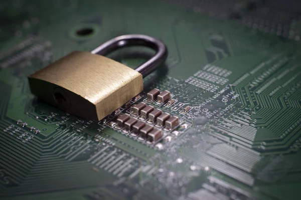 Brass lock sitting on electric circuit as concept of internet data security. Close-up full frame viewed from above with copy space