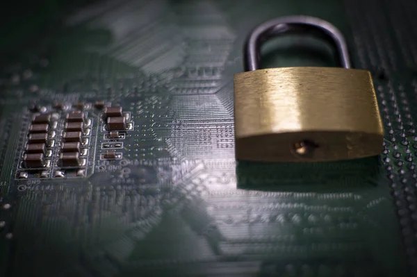 Metal lock sitting on electric circuit as concept of internet data security. Close-up full frame viewed from above with copy space