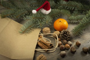 Çeşitli fındık, tarçın ve clementine tatil bakkaliye, kavram olarak yaymak Kağıt alışveriş çantası, köknar ağacı dalı ile yüksek açıdan yakın çekim görüntülenen dışında ahşap tablo