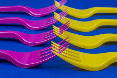 Renkli mor ve sarı plastik çatal ile birbirine dişleri bir çapraz çizgi mavi tam kare görünümü'nde düzenlenen