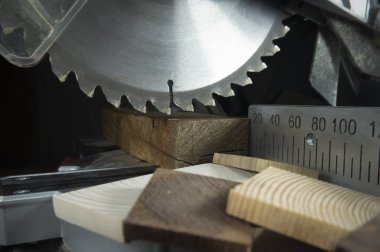 Ahşap ve metal bir ölçek kesme uzunlukları bir ağaç işleme atölye için çeşitli bloklar ile yakın dairesel bir güç dişlerde görmüş