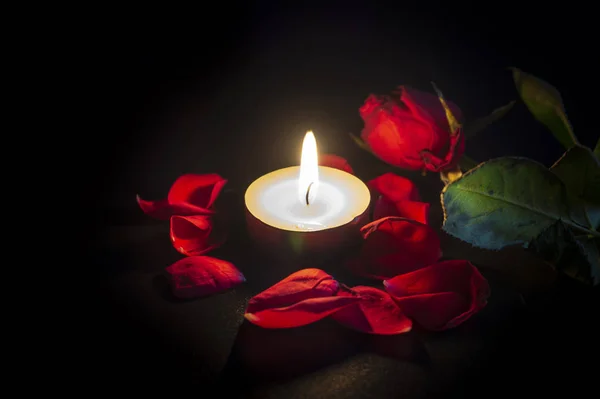 Vela de chá, rosa vermelha e pétalas de rosa em preto — Fotografia de Stock