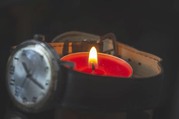 Relógio de pulso com uma vela de chá vermelho ardente — Fotografia de Stock