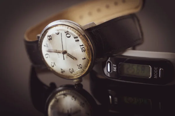 Cadran d'une montre-bracelet reflété sur une table — Photo