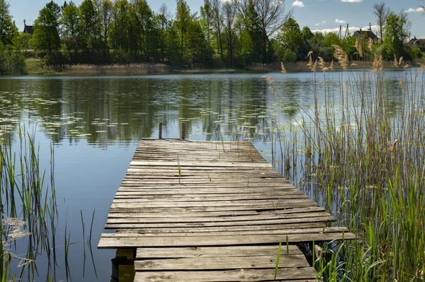 Gammal rustik träbrygga på en lugn sjö — Stockfoto