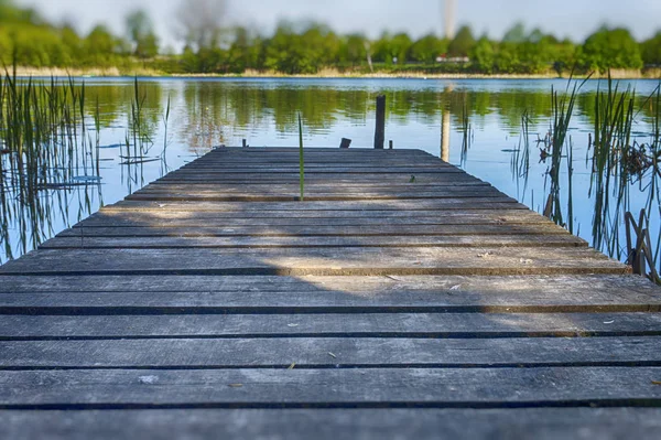 Gammal rustik träbrygga på en lugn sjö — Stockfoto