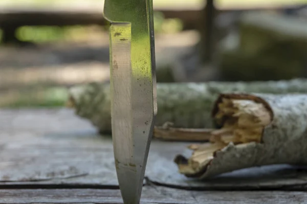 Skládací nůž vzpřímený ve starém piknikovým stole — Stock fotografie