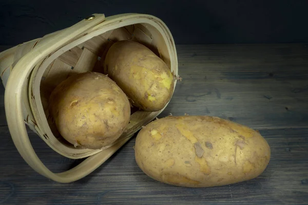 Patate che fuoriescono dal cestino di vimini rovesciato — Foto Stock