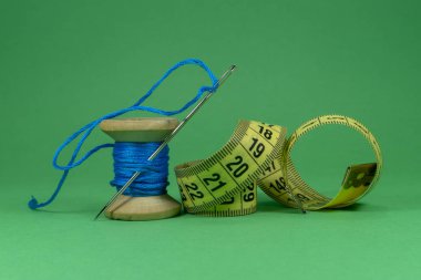 Mavi iplik, bant ölçüsü ve dikiş iğnesi