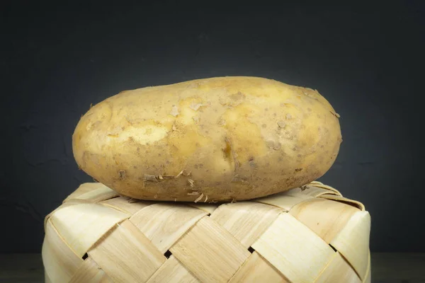 Patata fresca su un cesto di vimini rovesciato — Foto Stock