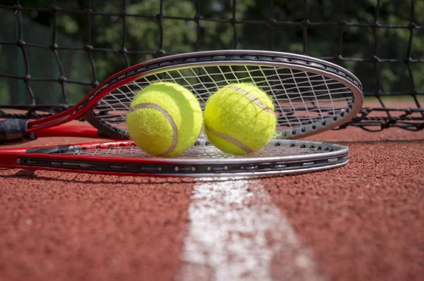 Tennis scene with black net, balls and racquet