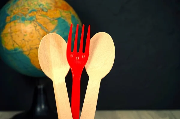 Wooden handcrafted spoons and fork with globe — Stock Photo, Image