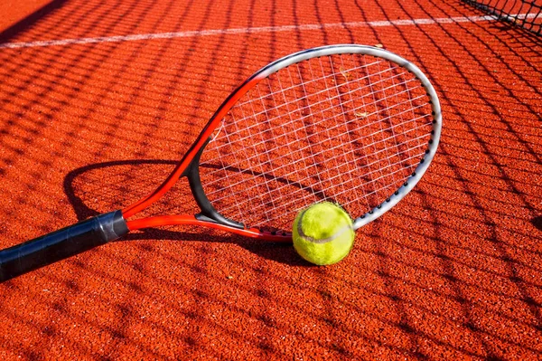 Tennis ball and racket on an outdoor court Stock Photo