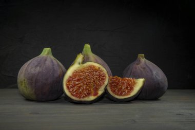 Tam bir incir ve bir dilim tahta masa.