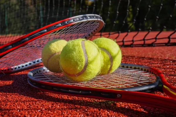 Tennis scene with black net, balls and racquet