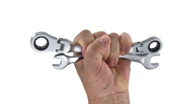 Beyaz arka planda iki anahtarı sıkıca tutan bir elin yakın plan çekimi. Aletler parlak metalden yapılmıştır..