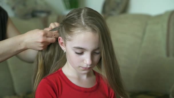 Kadının elleri küçük kızı için saç modeli yapmak. Bir kadın kızı için saç örgü. — Stok video