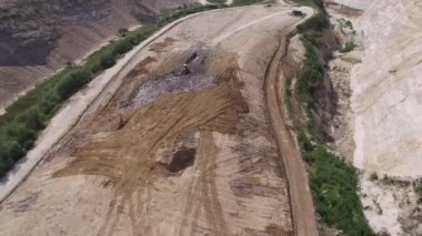 Kazıcı çöp hurdalıkta taşır. Hava atışı.