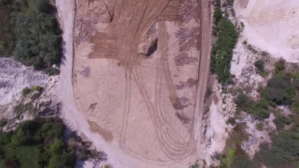 Graafmachine beweegt vuilnis in autokerkhof. Luchtfoto. — Stockvideo