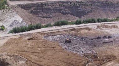 Kuşlar aroud çöp yığını çalışma Ekskavatör yakınındaki hurdalık sinek. Hava atışı.