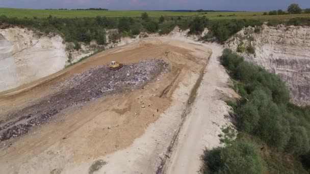 Digger moves garbage in junkyard. Aerial shot. — Stock Video