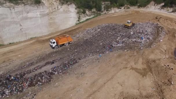 Een vrachtwagen lossen vuilnis te autokerkhof. Luchtfoto. — Stockvideo