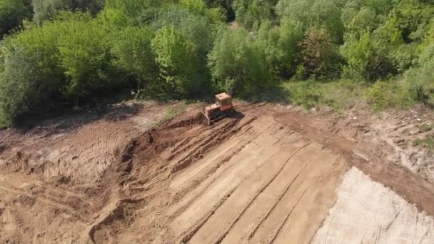 Aerial view of bulldozer flattening hill surface on further construction site — Stock Video
