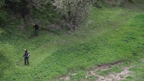 タイムラプス: 2人の男性がトリマーと草を刈る — ストック動画