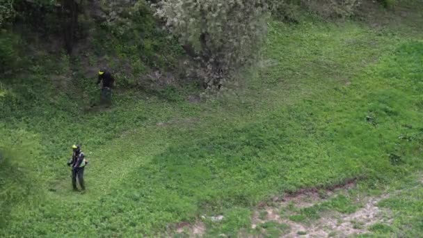 Timelapse: två män klippa gräs med trimmers — Stockvideo