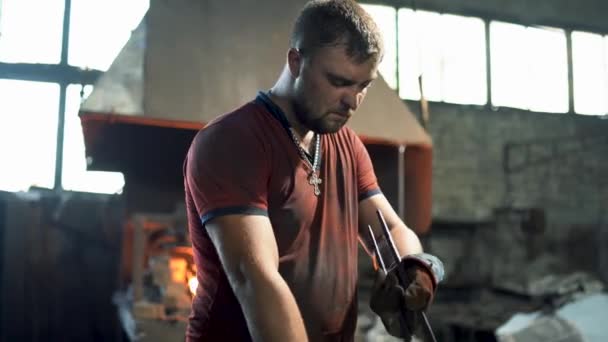 A blacksmith uses a hand hammer on an anvil to forge a red hot metal product — Stock Video