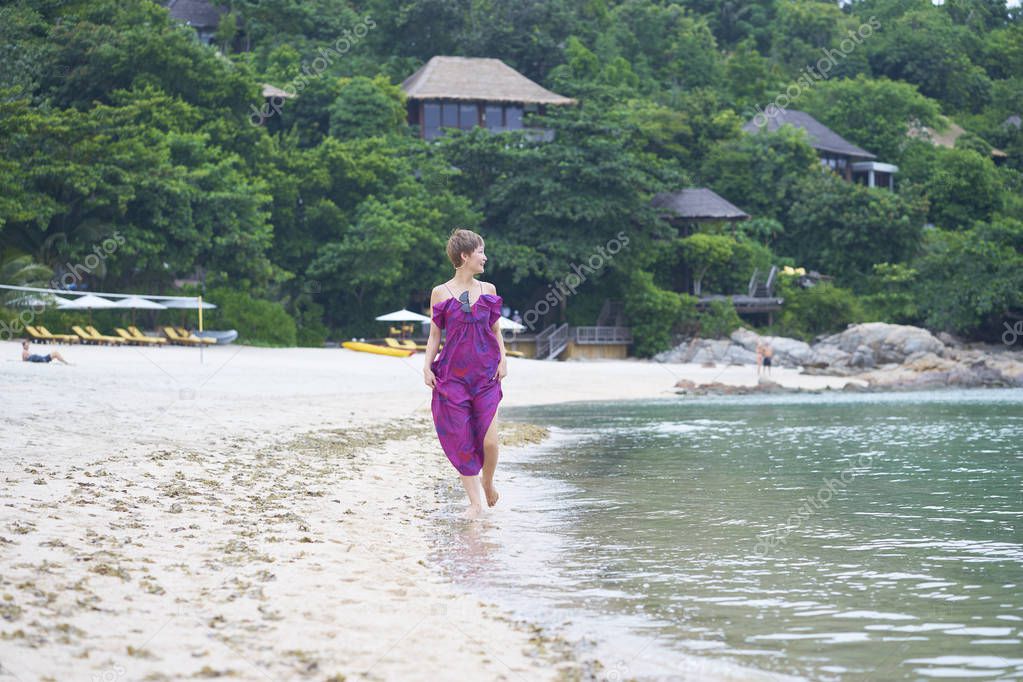 Asian beauty walking on beach during her vacation in tropical resort