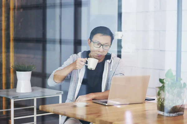 사무실에서 노트북에서 커피를 마시는 아시아 실업가의 초상화 — 스톡 사진