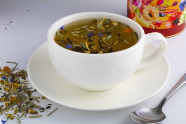 Cam fincan nane ile siyah çay. Tahta kaşık çay yaprakları. Arka plan beyaz izole